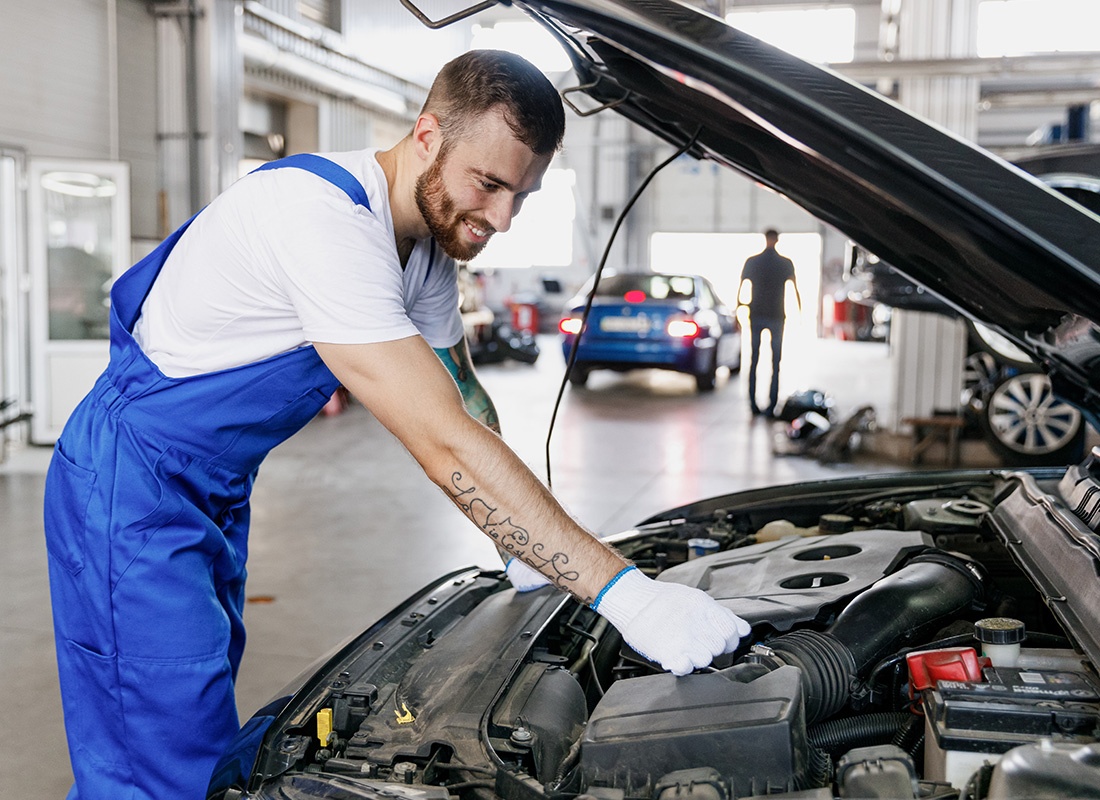 Business Insurance - Friendly Auto Technician Fixing a Car at a Shop