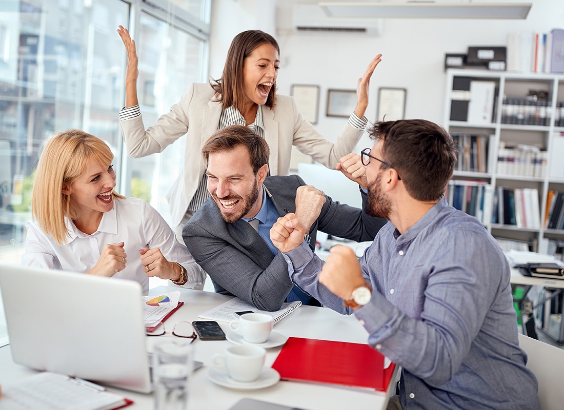 Read Our Reviews - Group of Office Workers Cheering Together After Getting a Good Report